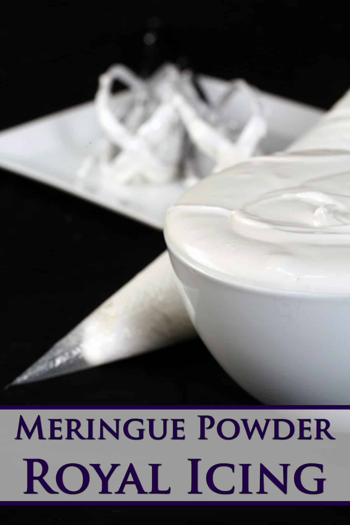 A bowl of meringue powder royal icing, along with a pastry bag full of it, and a set of mixers on a plate.