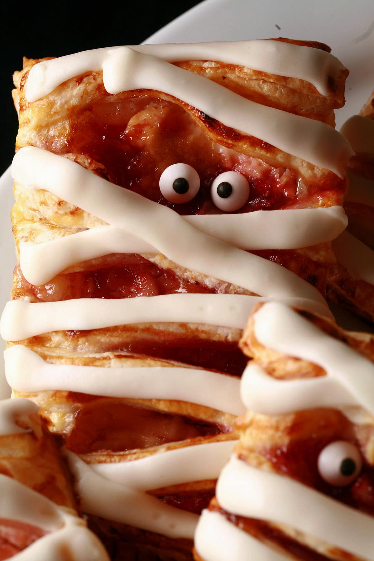 A plate of mummy pastries-raspberry cream cheese danishes, Halloween style.