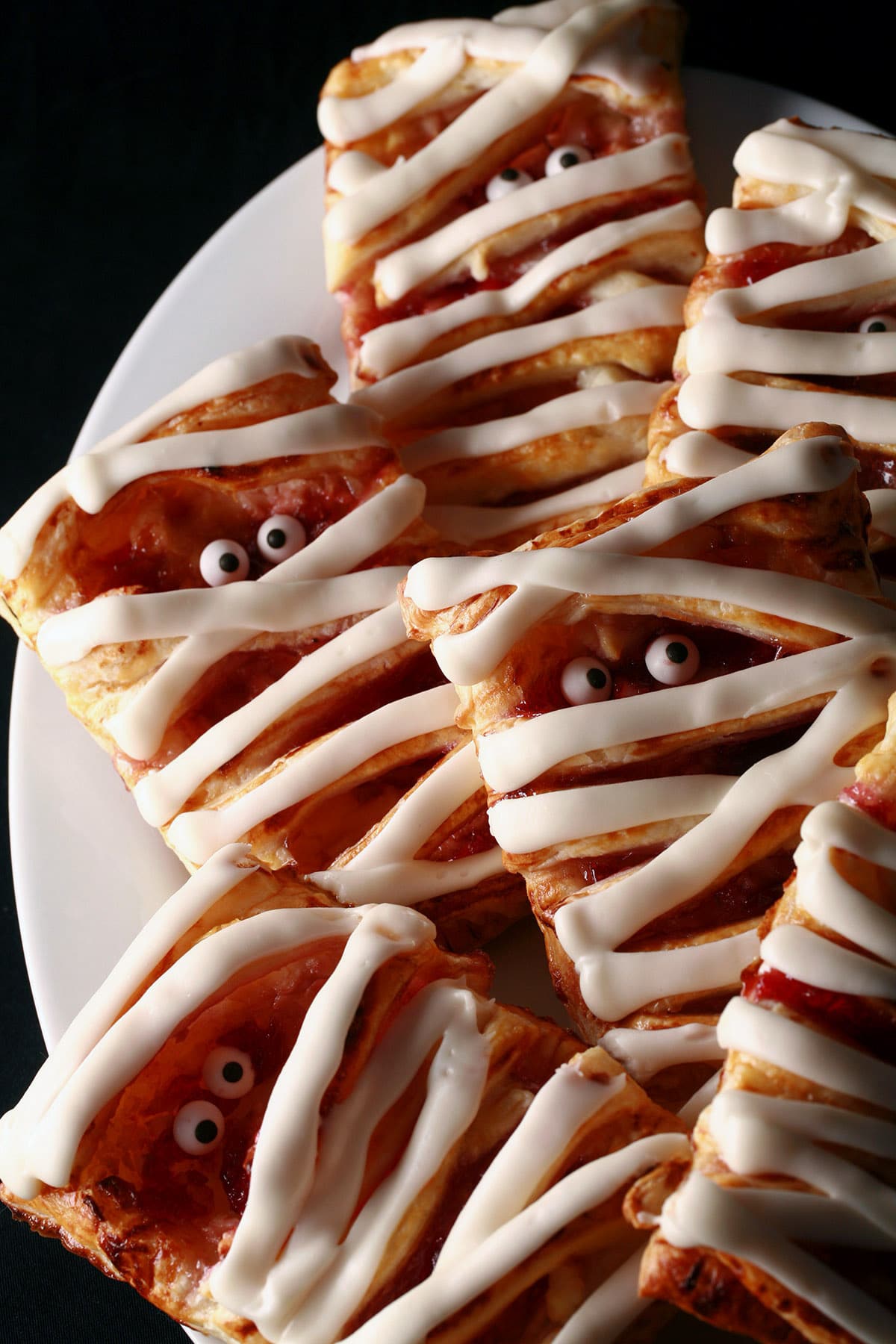 A plate of mummy pastries-raspberry cream cheese danishes, Halloween style.