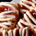 A plate of mummy pastries-raspberry cream cheese danishes, Halloween style.