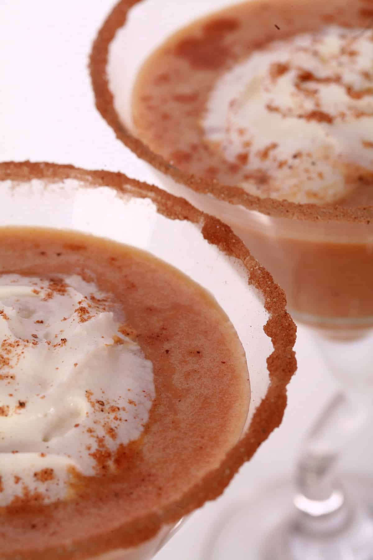 2 Pumpkin Martinis with spiced sugar rim and whipped cream.