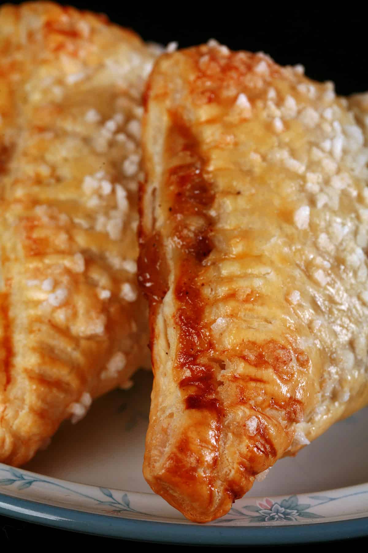 2 sugar crusted apple turnovers on a plate.