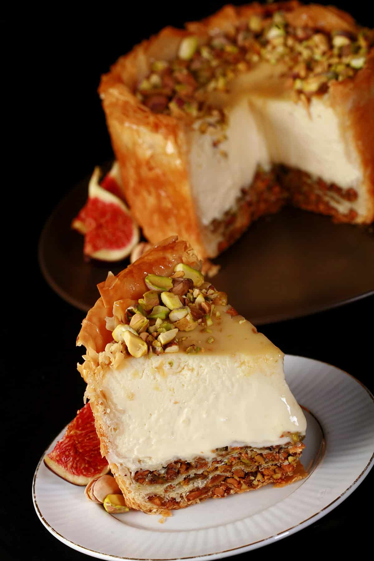 A slice of baklava cheesecake, in front of the rest of the mini cheesecake.