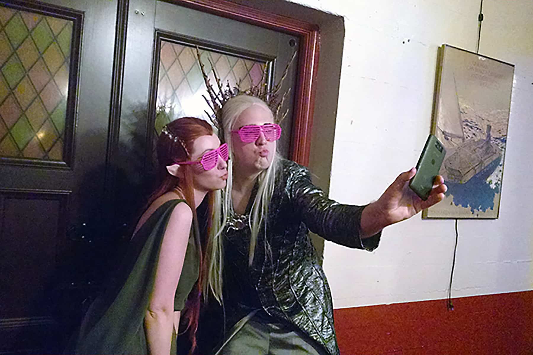 Two cosplayers dressed as Tolkien elves, taking a selfie together.