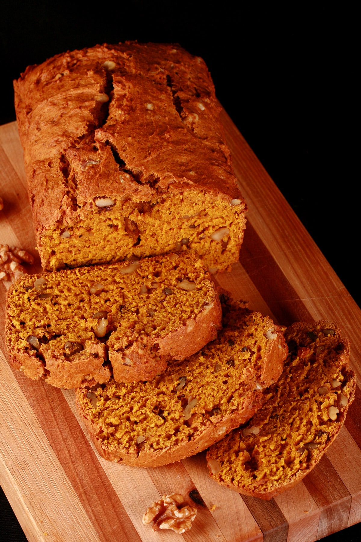 A loaf of sliced pumpkin bread on a cutting board.