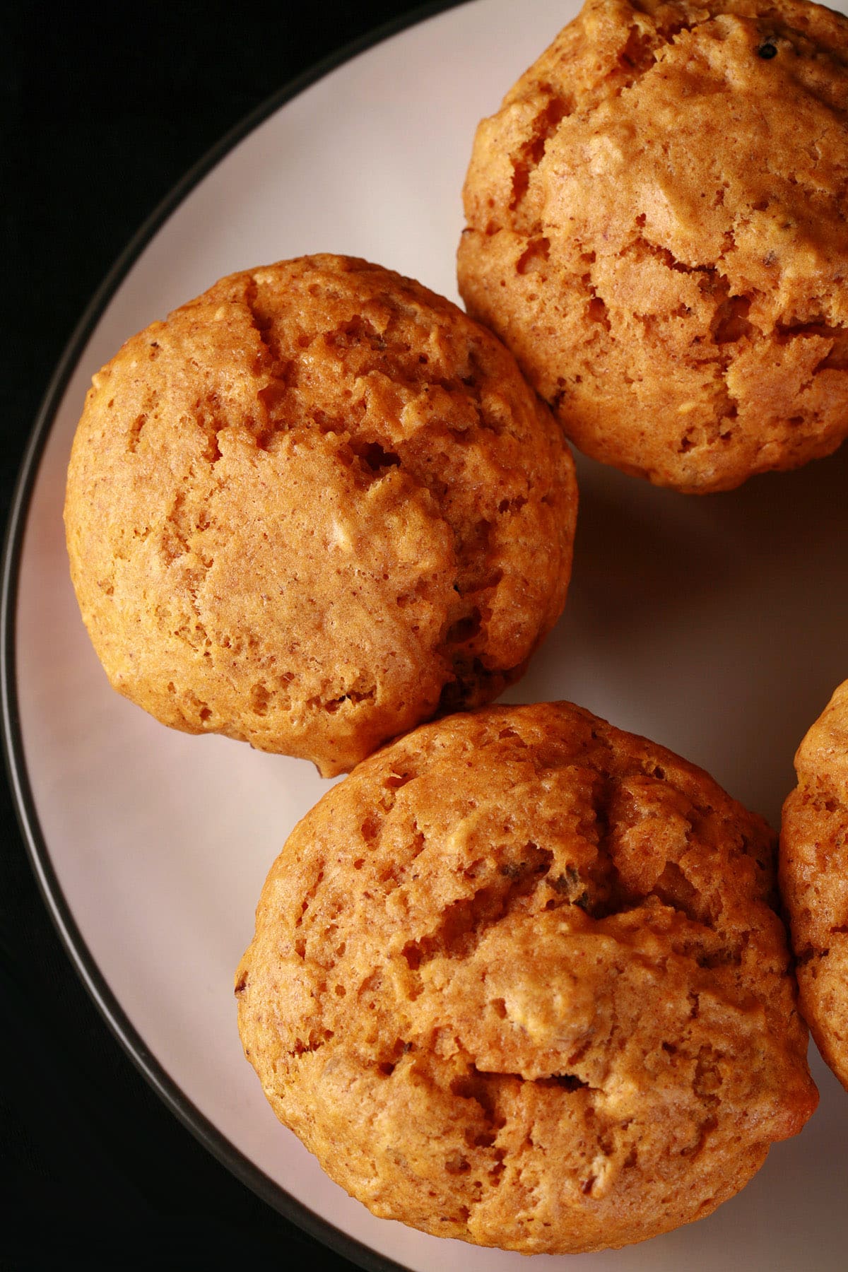 Several maple pumpkin muffins on a plate.