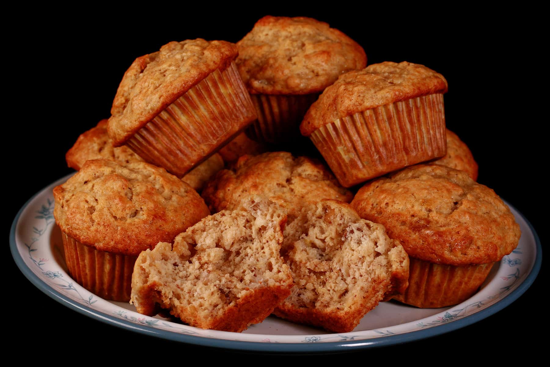 A plate of banana walnut muffins with one broken in half.