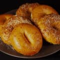 A plate of roasted red pepper bagels, some with Parmesan cheese on top.
