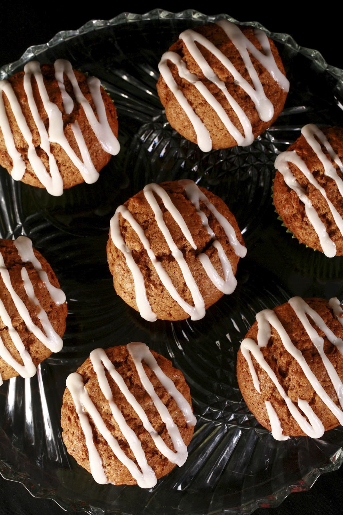 A plate of homemade gingerbread muffins, each drizzled with a white glaze.