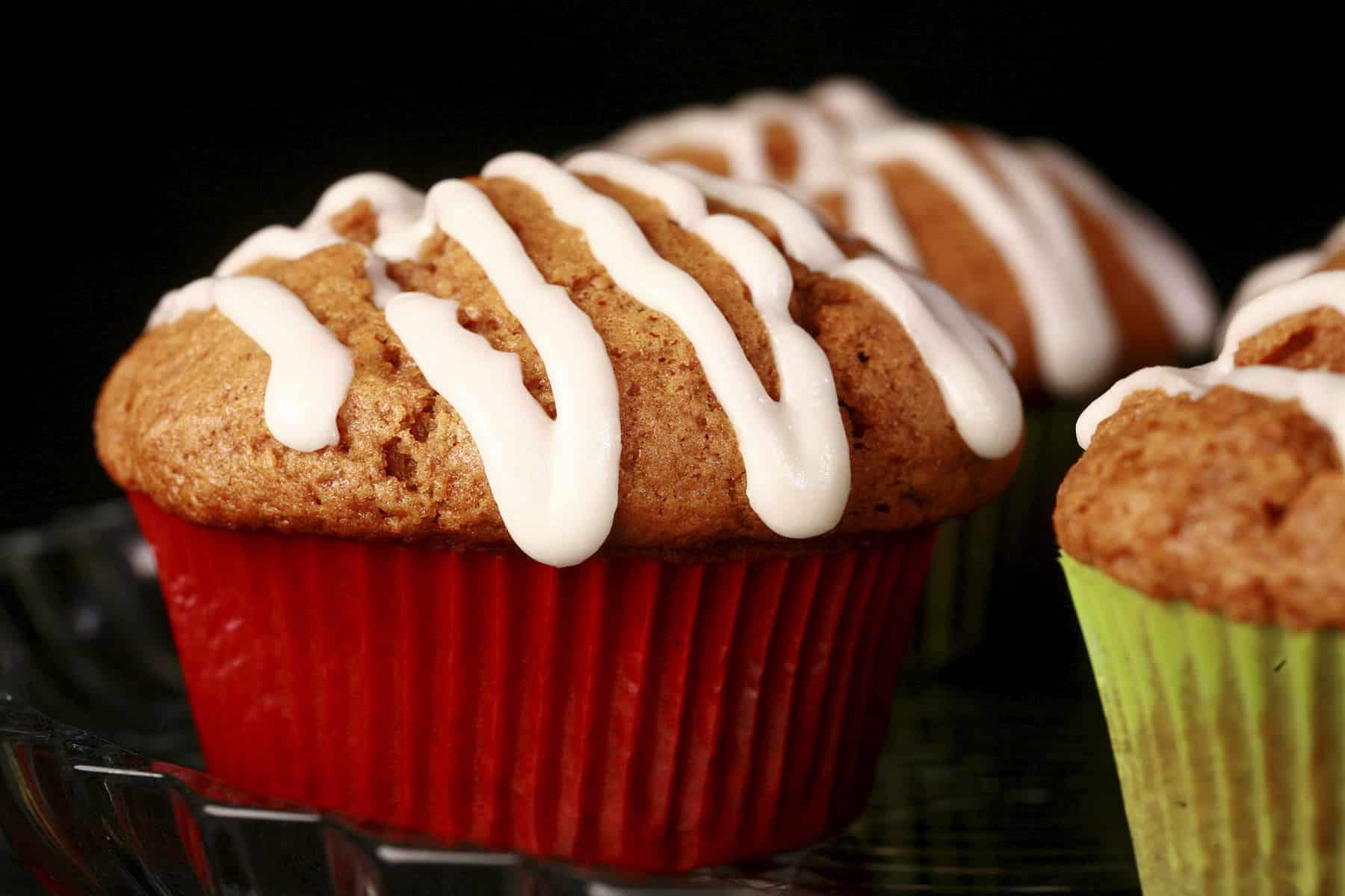 A plate of homemade gingerbread muffins, each drizzled with a white frosting.