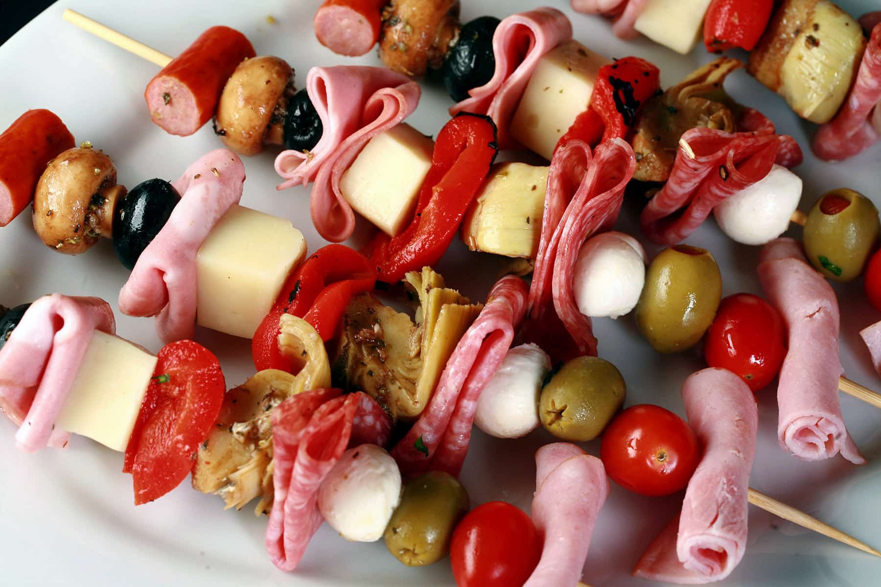 Several antipasto skewers on a plate.