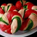 Several candy cane style Christmas bagels on a plate.