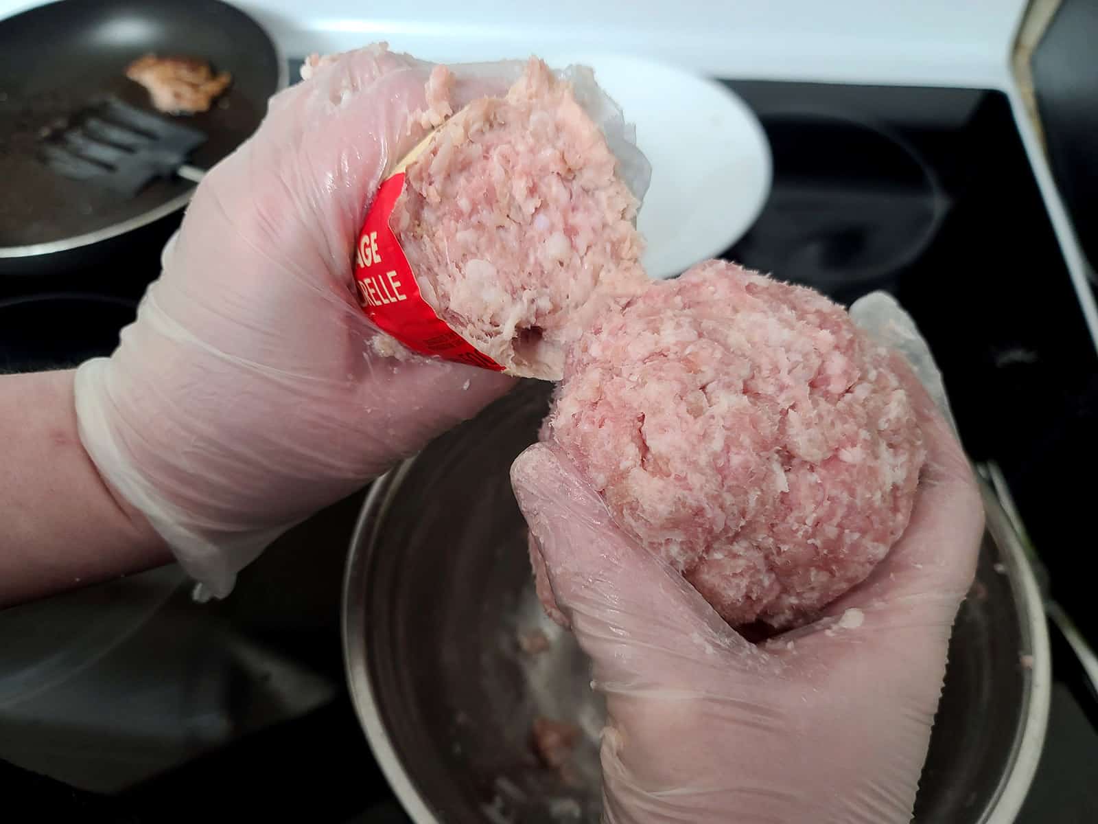 Two hands holding Maple Leaf sausage in one hand, and homemade ground sausage meat in the other.