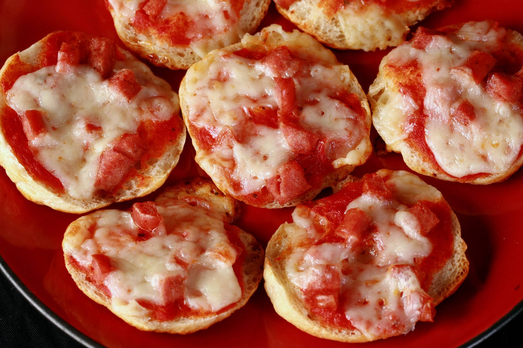 A plate of pepperoni and cheese homemade bagel bites pizza snacks.