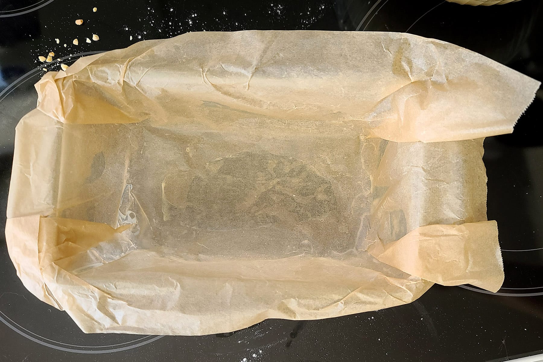 A loaf pan that’s been sprayed with pan spray before being lined with parchment paper.