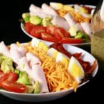 2 bowls of quick cobb salad with rolled deli chicken and a bottle of lemon ranch vinaigrette.