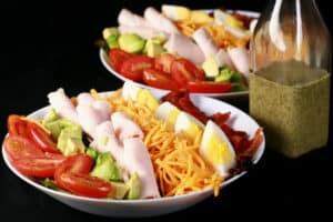 2 bowls of quick cobb salad with rolled deli chicken and a bottle of lemon ranch vinaigrette.