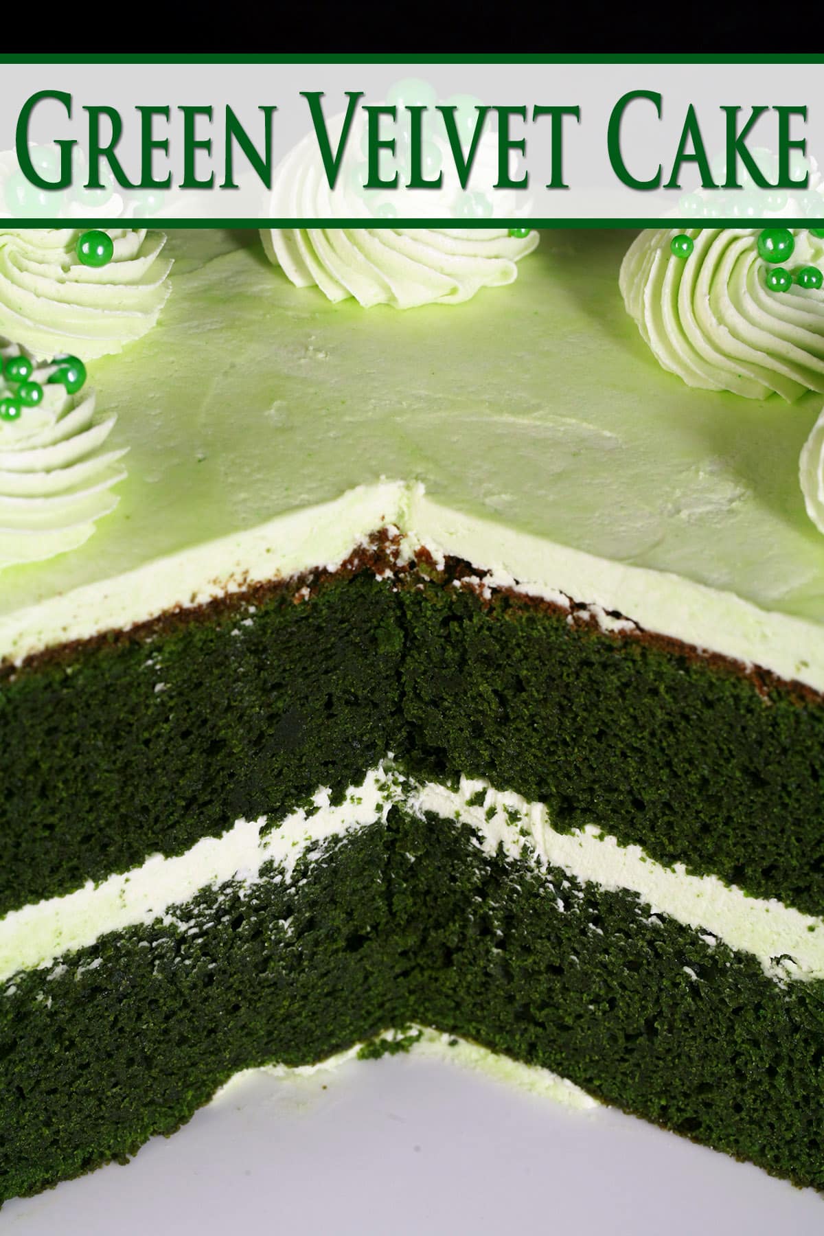 A green velvet cake cut  open to show two layers of dark green cake, with light green frosting in between and all around.