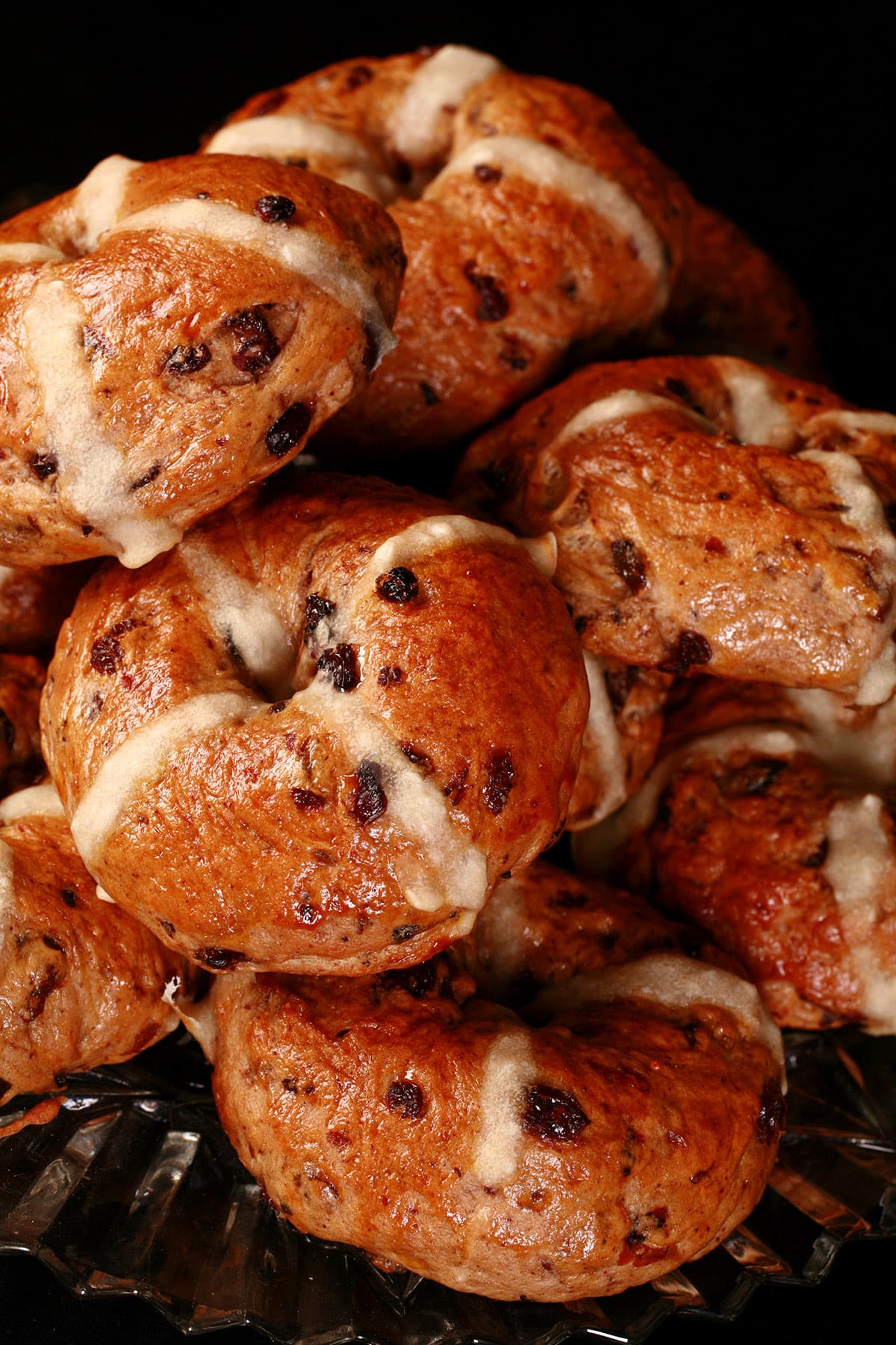A pile of hot cross bagels on a plate.