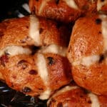 A pile of hot cross bagels on a plate.