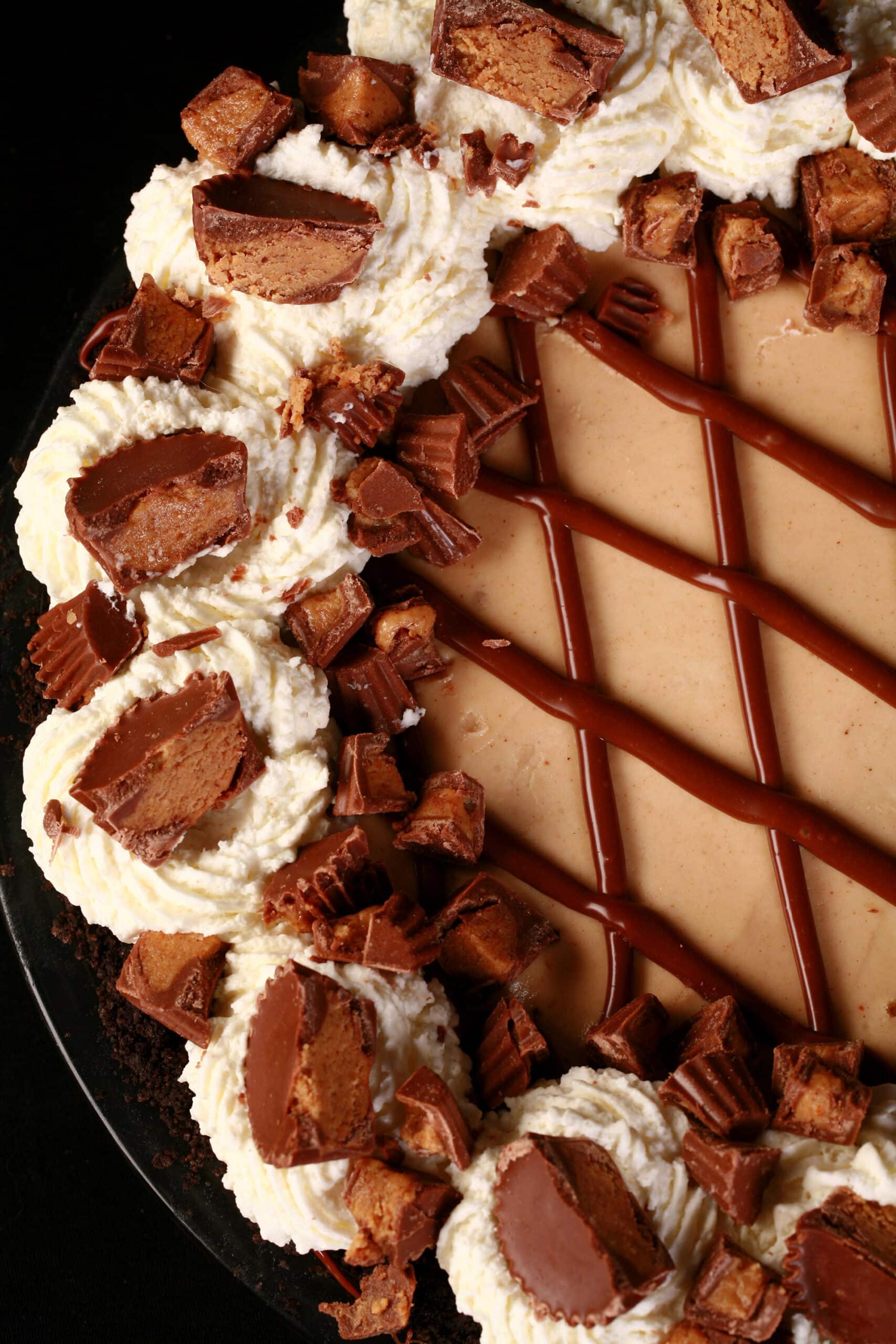 A Reese’s Peanut Butter Pie, with chocolate lattice top,  whipped cream rosettes, and chopped peanut butter cups.