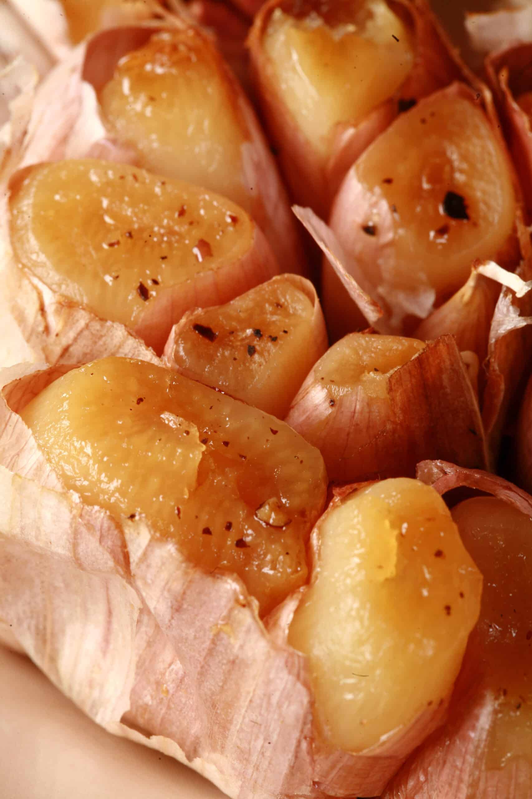 A close up photo of a bulb of roasted garlic.