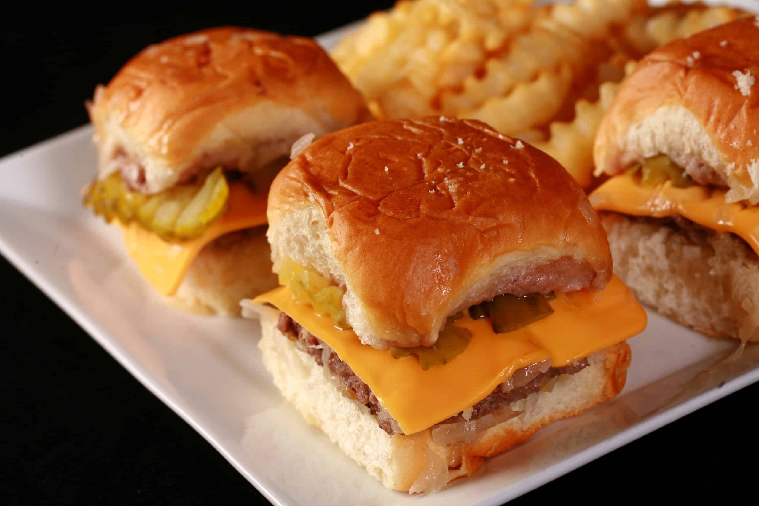 Several homemade white castle burgers on a plate.