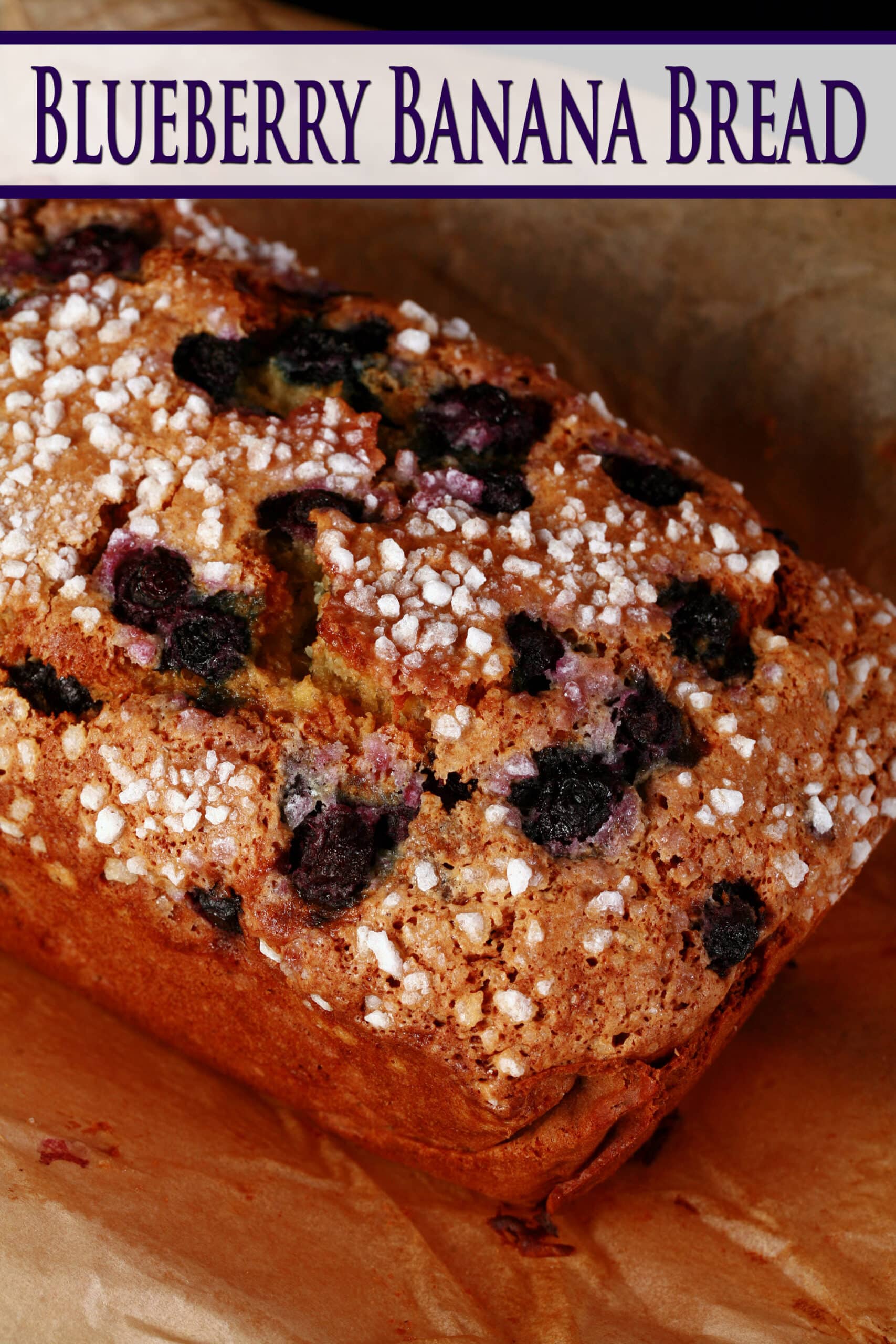 A loaf of blueberry banana bread on a cutting board.