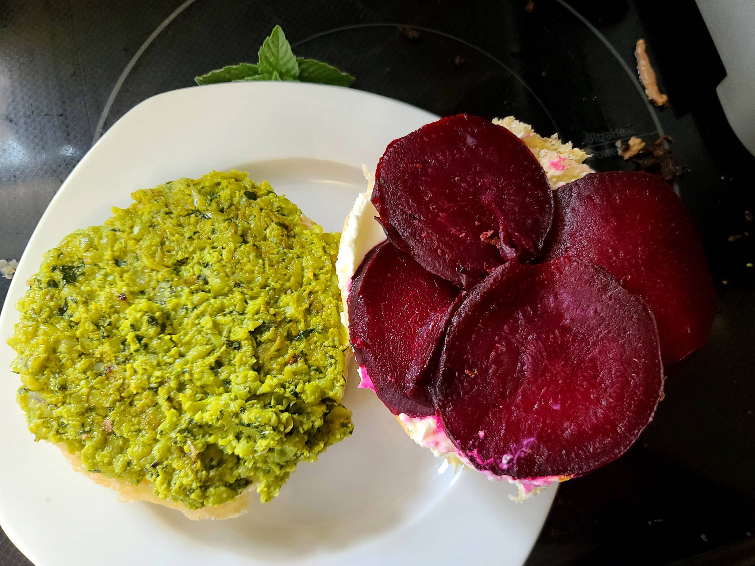 A bun prepared with goat cheese spread, roasted beets, and pea hummus.