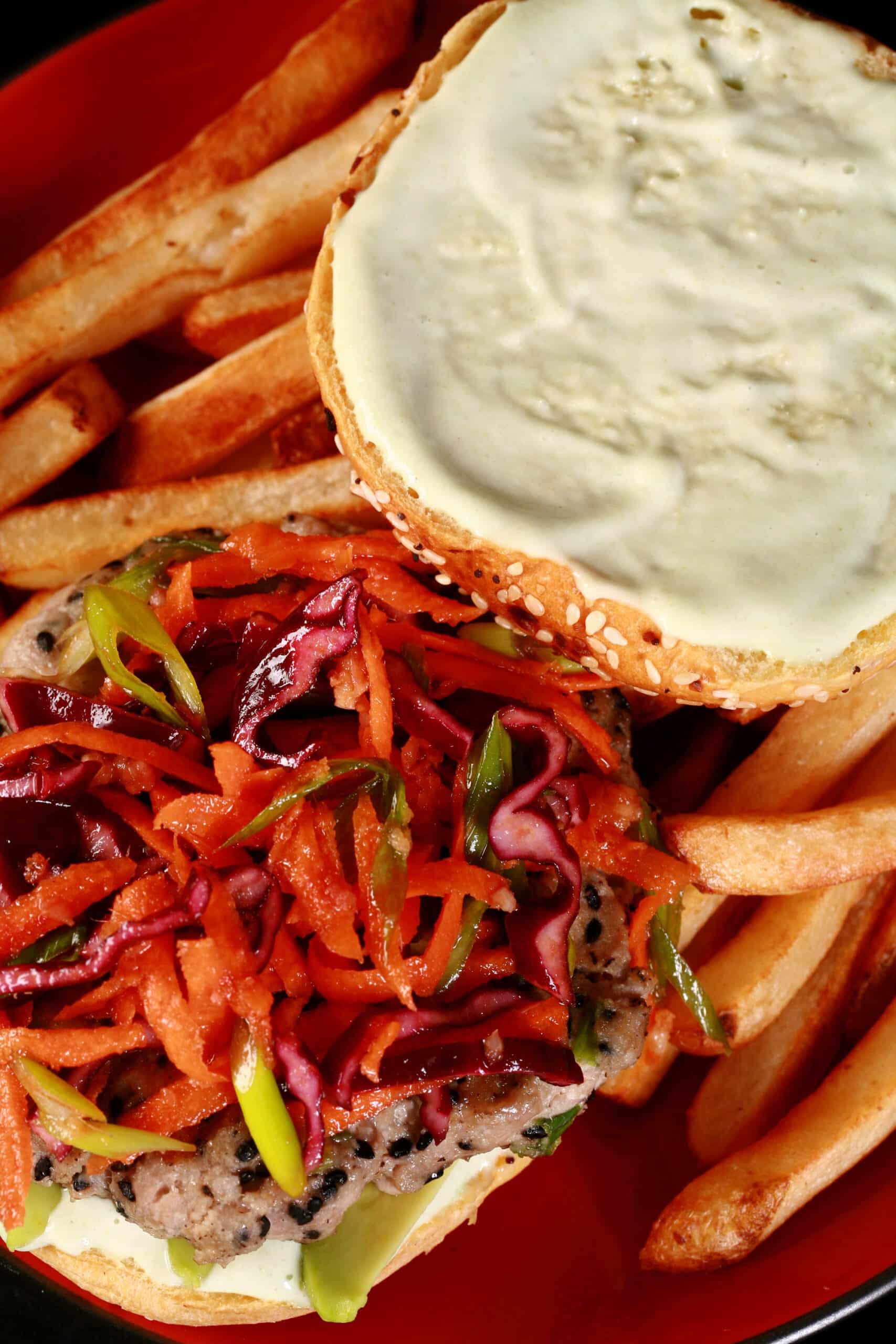 A tuna burger with ginger slaw and wasabi mayo, on a plate with fries.