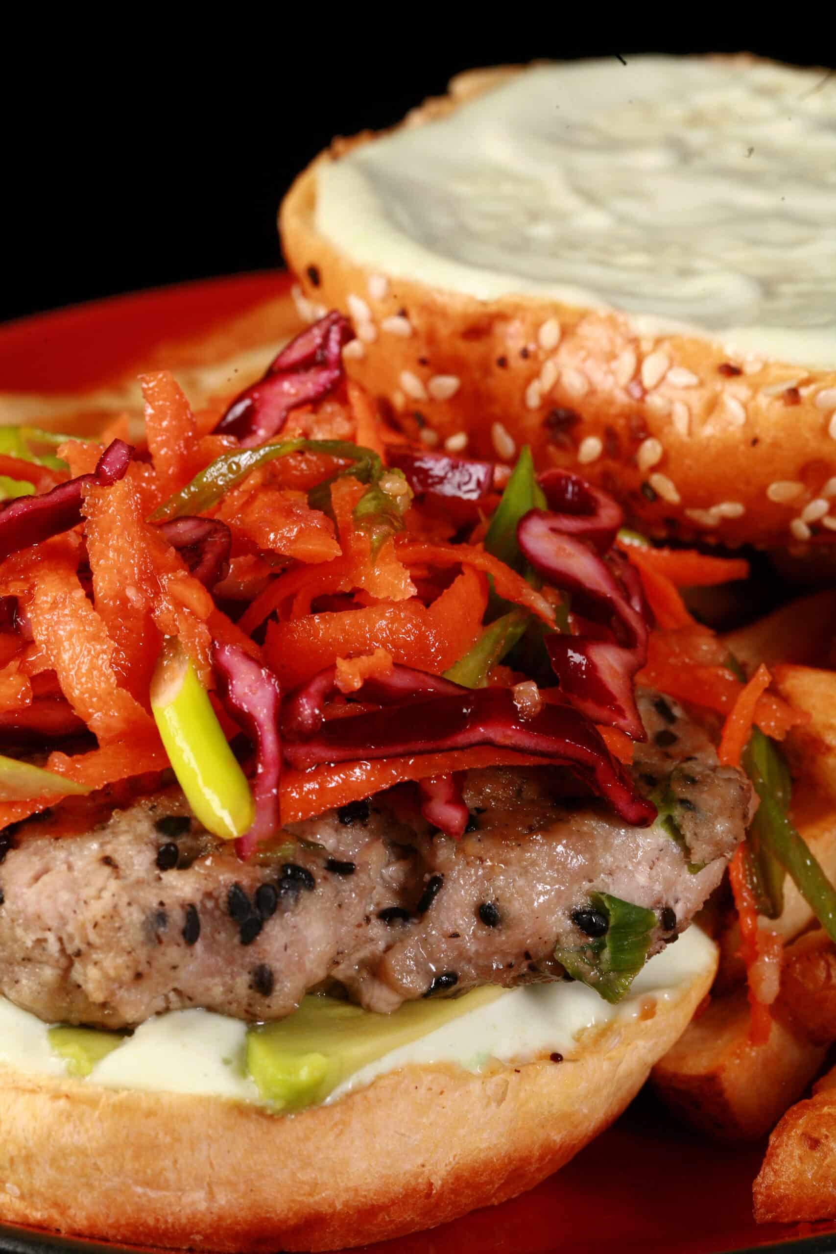 A tuna burger with ginger slaw and wasabi mayo, on a plate with fries.