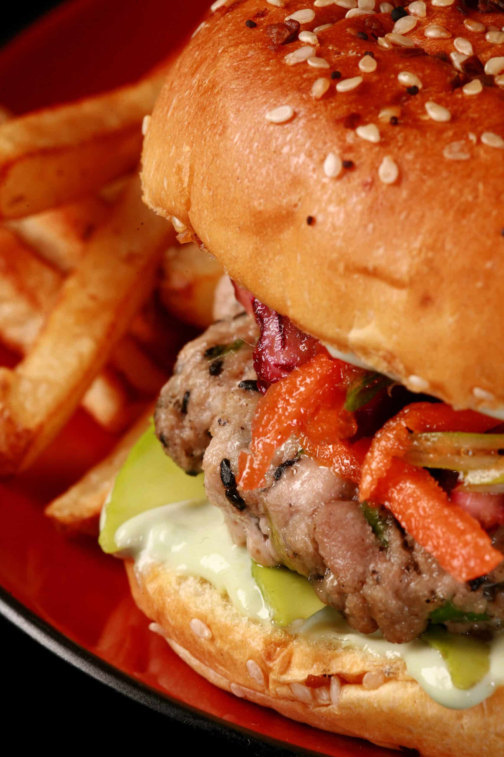 A tuna burger with ginger slaw and wasabi mayo, on a plate with fries.