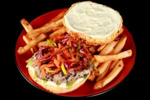 A tuna burger with ginger slaw and wasabi mayo, on a plate with fries.