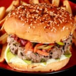 A tuna burger with ginger slaw and wasabi mayo, on a plate with fries.