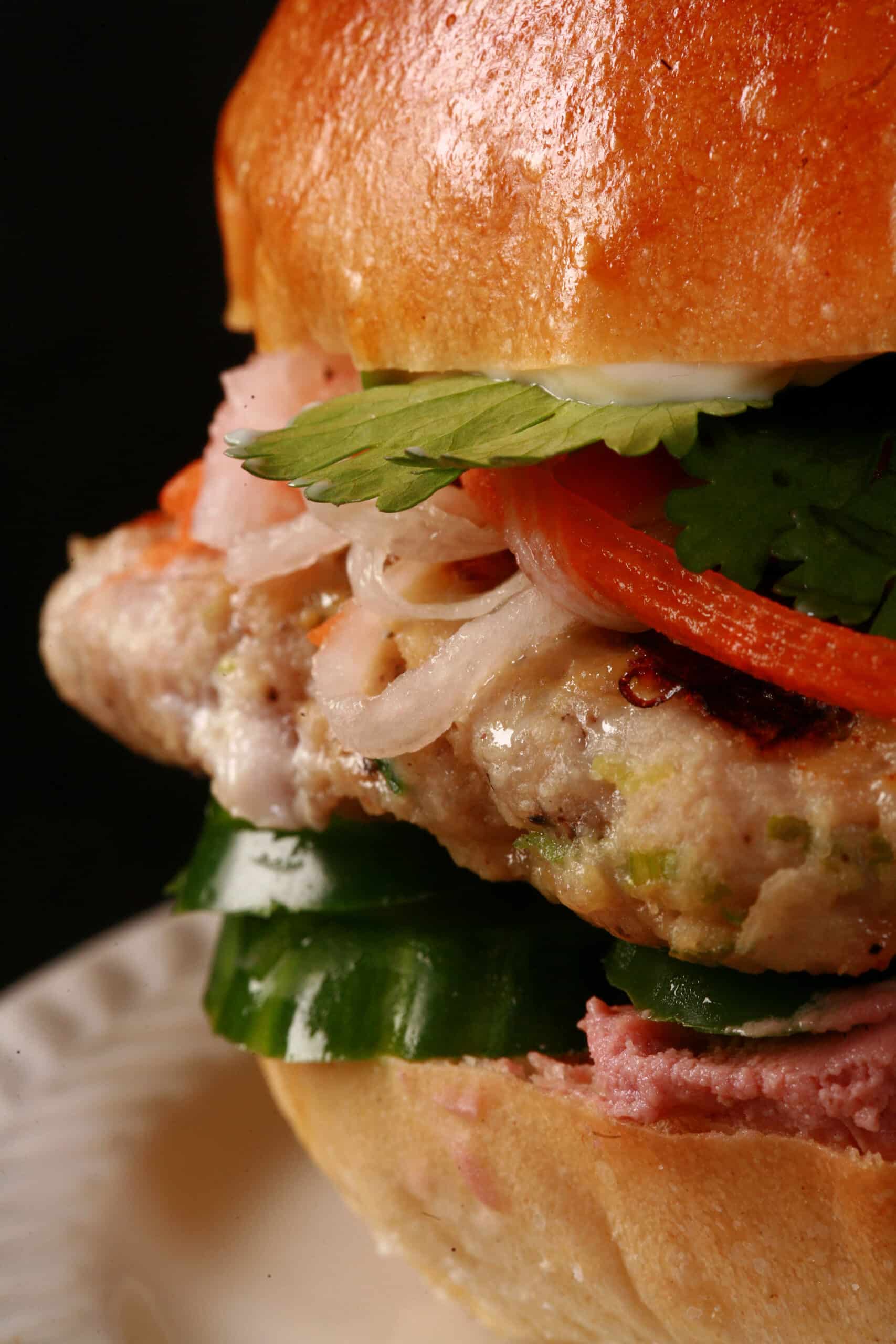 A close up view of a lemongrass chicken banh mi burger.