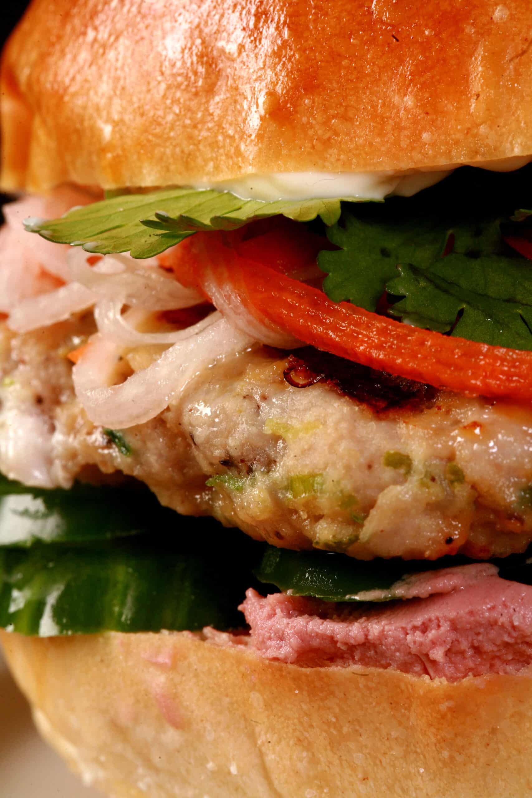 A close up view of a lemongrass chicken banh mi burger.