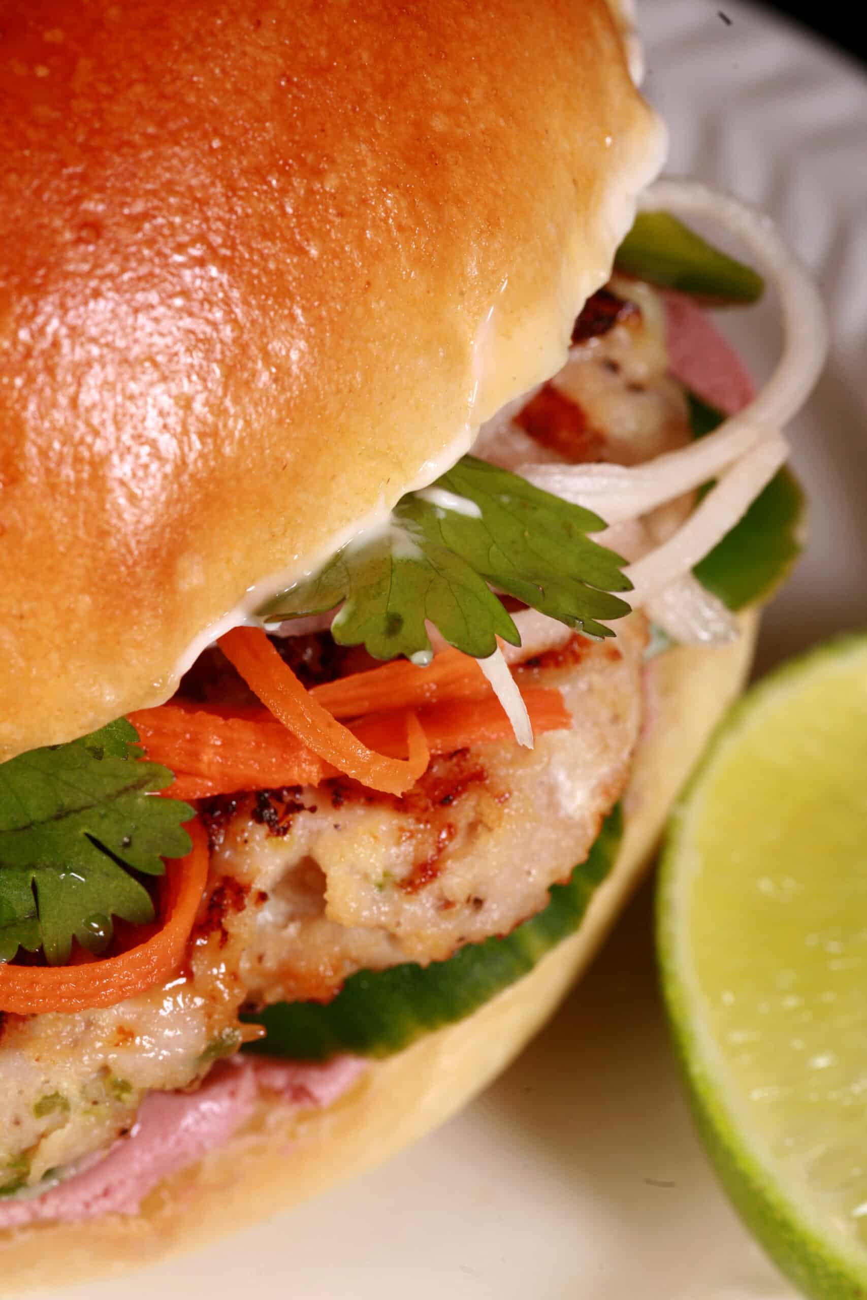 A close up view of a lemongrass chicken banh mi burger.