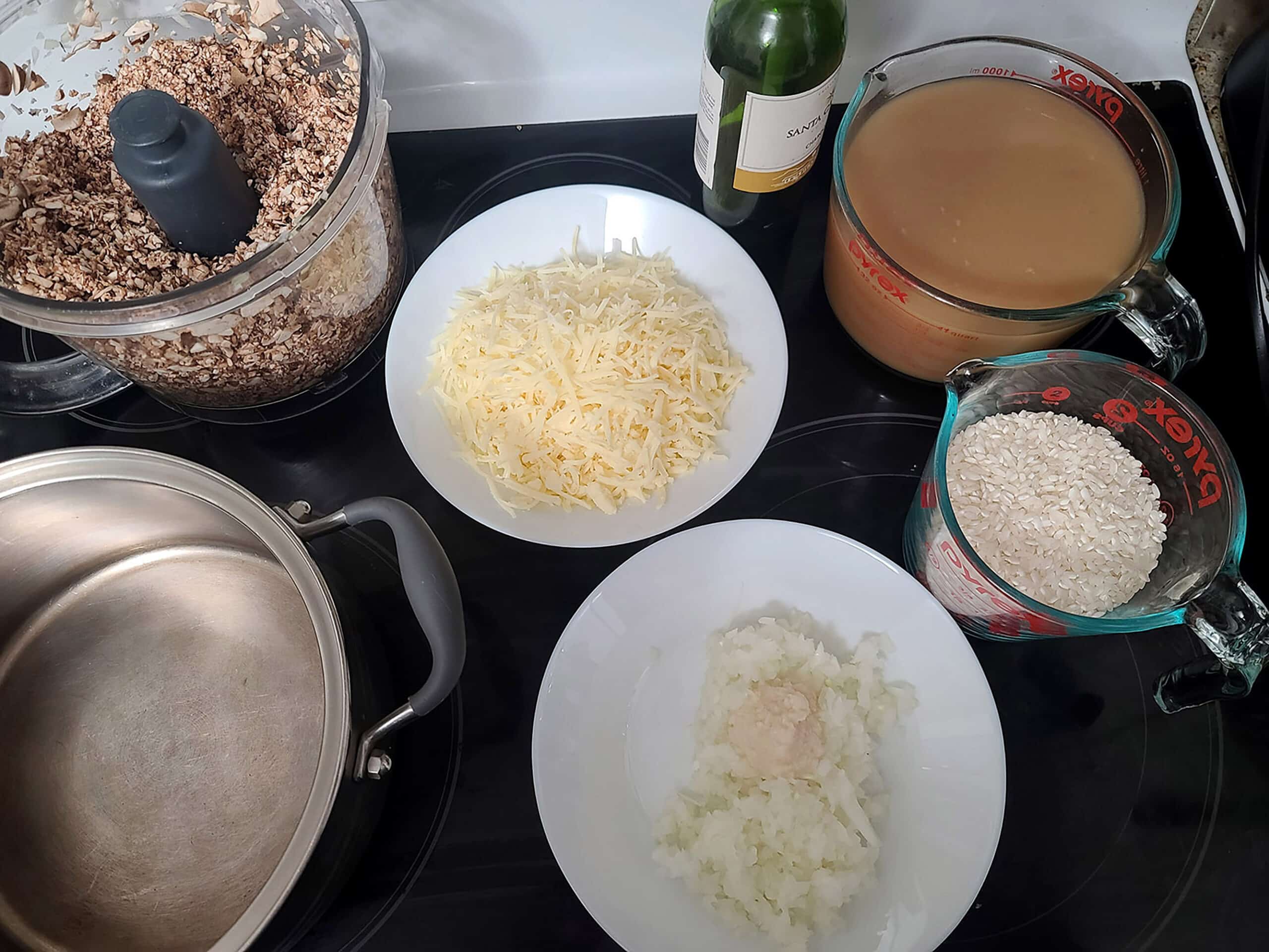 All of the mushroom risotto ingredients laying on a stove top.