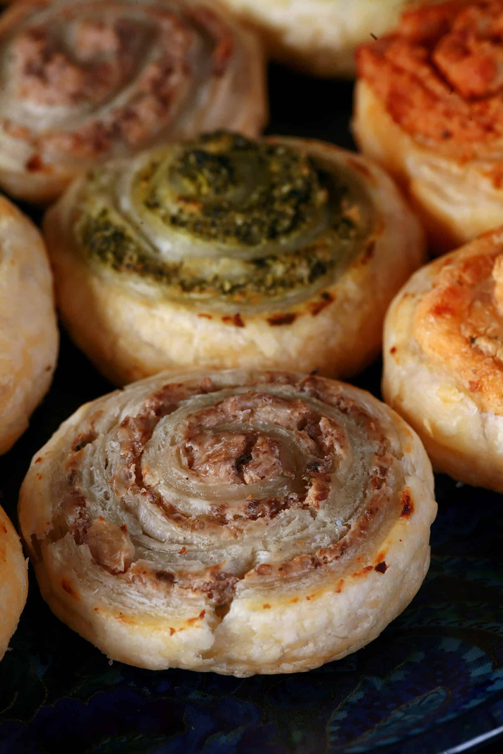 Mushroom, Spinach, Onion, and sun dried tomato spiral puff pastry hors d’ouevres on a plate.