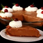 A gingerbread cream pie, garnished with whipped cream, cranberries, and rosemary.