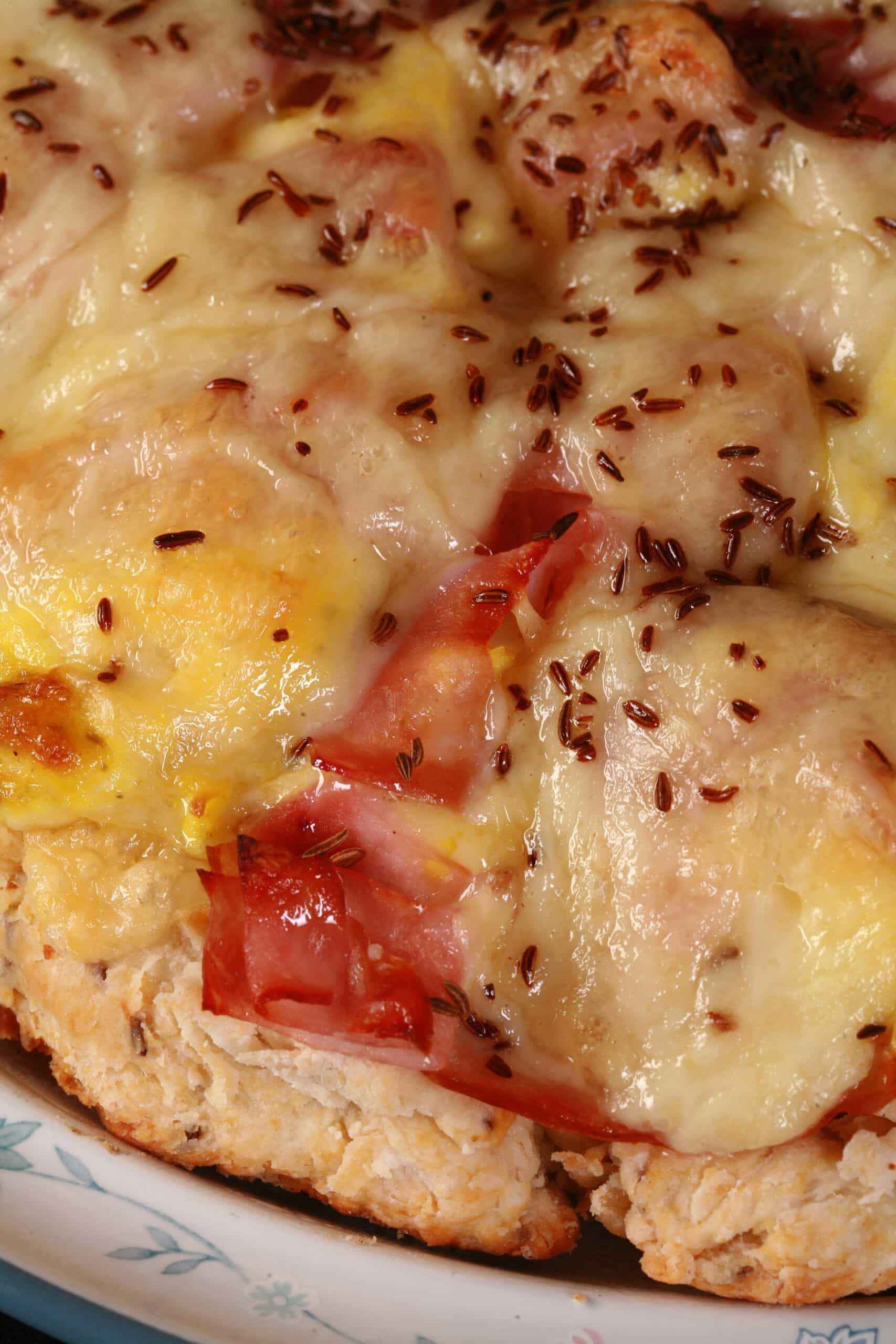 A ham and swiss cheese breakfast pizza on a biscuit crust.