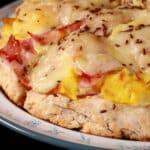 A ham and swiss breakfast pizza on a biscuit crust.