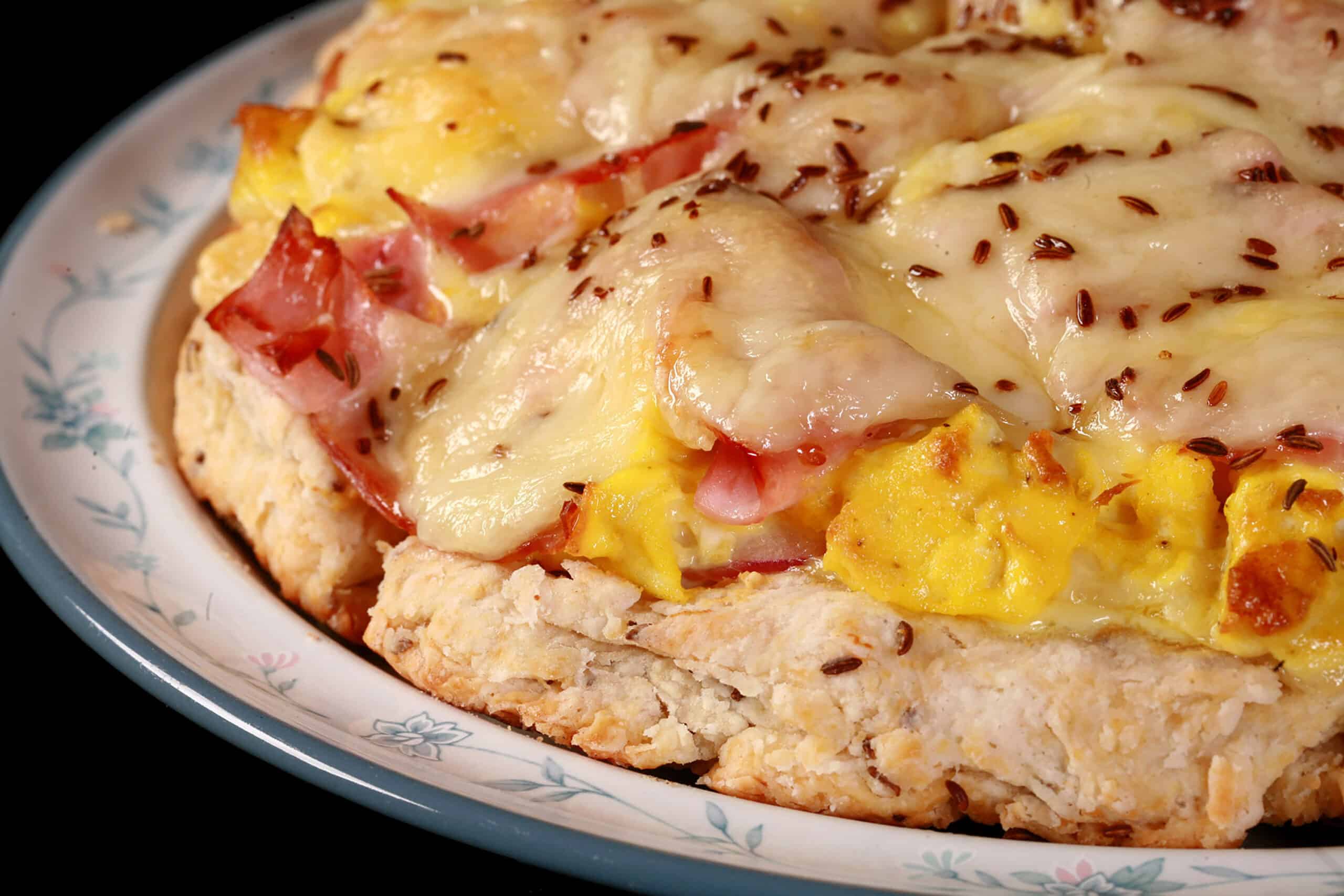 A ham and swiss breakfast pizza on a biscuit crust.