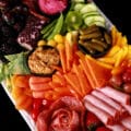 A rainbow charcuterie platter - all of the brightly coloured ingredients are arranged in ROYGBIV order.