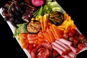 A rainbow charcuterie platter - all of the brightly coloured ingredients are arranged in ROYGBIV order.