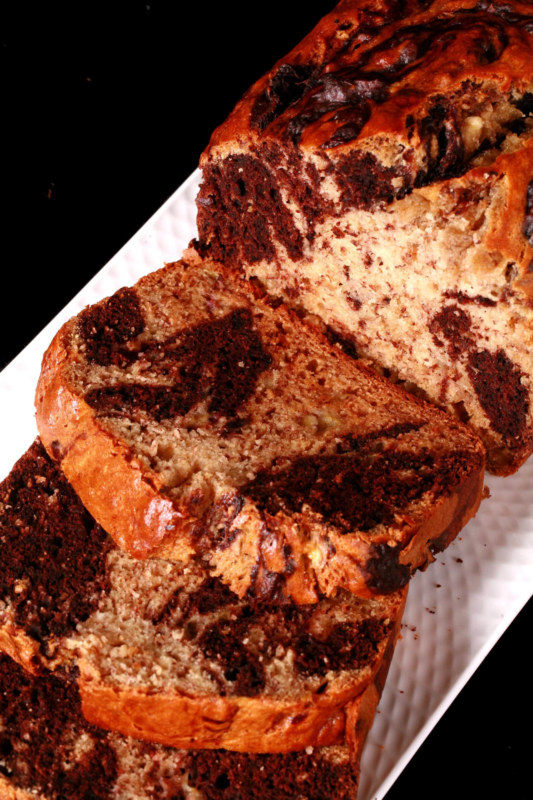 A sliced loaf of marbled peanut butter and chocolate banana bread.