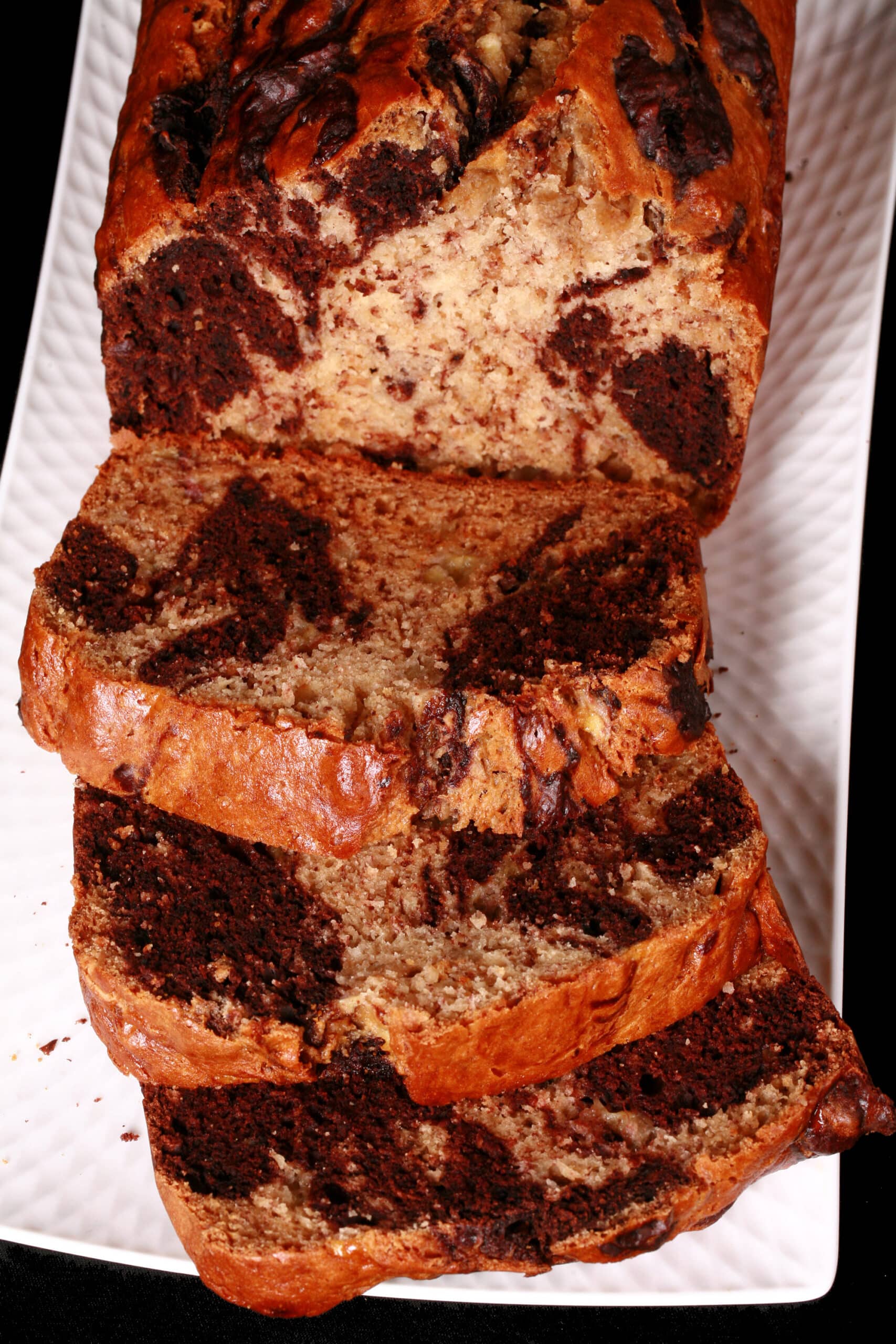 A sliced loaf of marbled chocolate and peanut butter banana bread.
