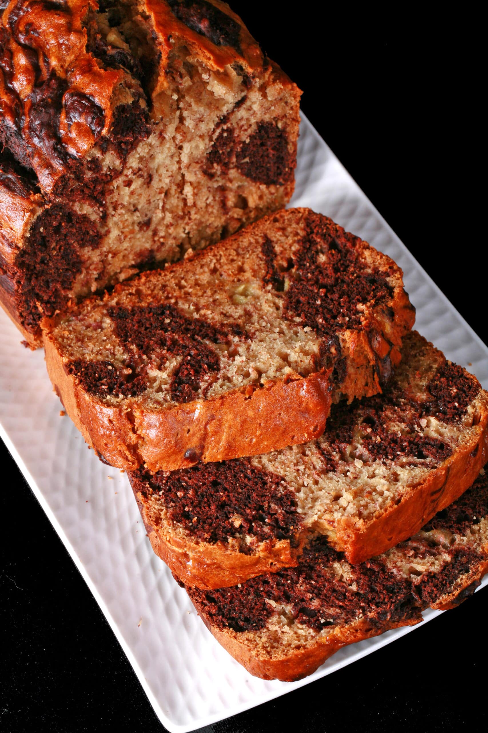 A sliced loaf of marbled peanut butter and chocolate banana bread.