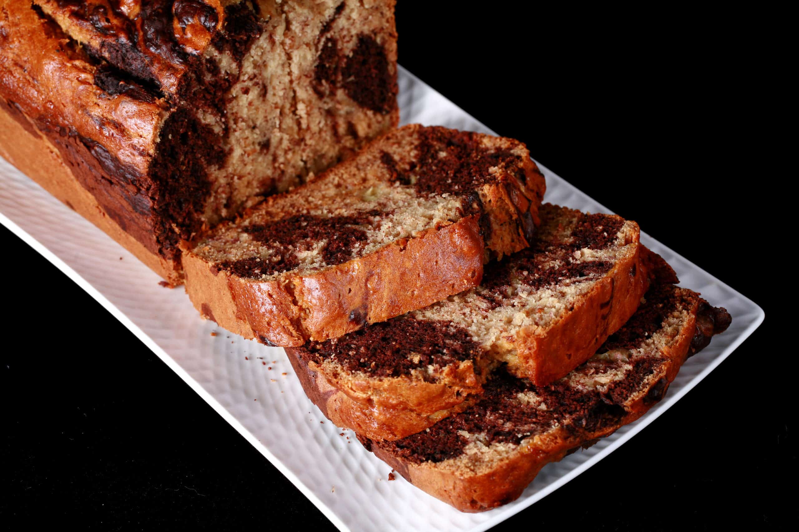 A sliced loaf of marbled peanut butter and chocolate banana bread.