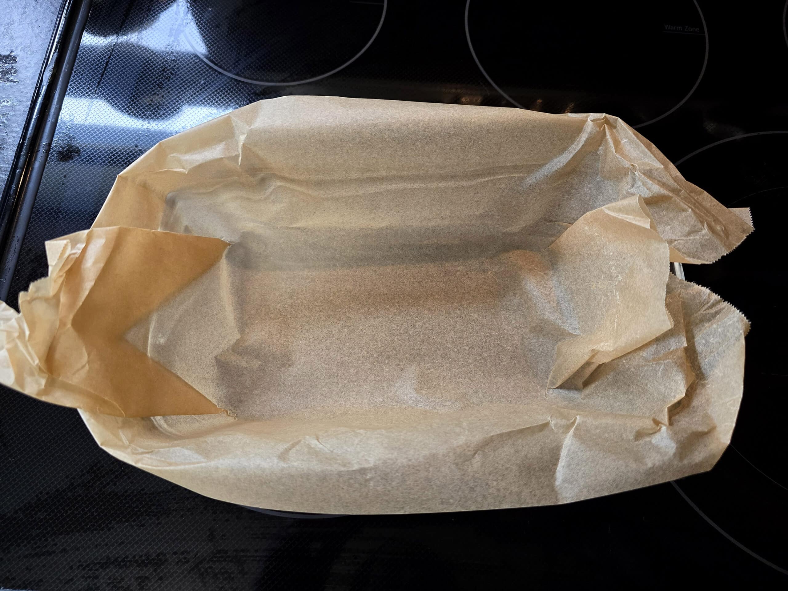 A loaf pan lined with parchment paper.